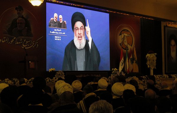 Hizbullah supporters watch as party leader Hassan Nasrallah delivers a speech on a screen in the southern Lebanese city of Nabatieh on January 12th. [Mahmoud Zayyat/AFP]