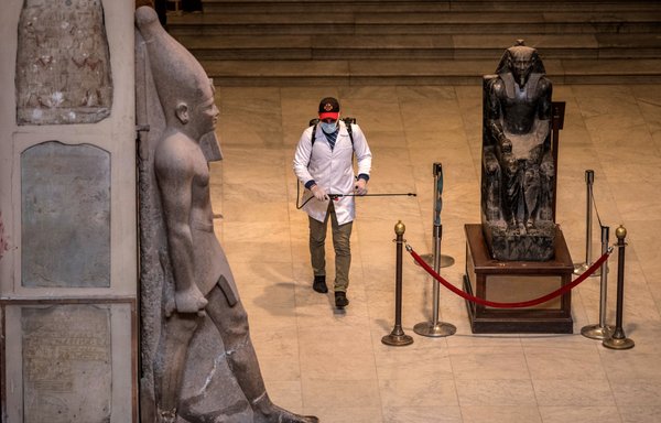 A worker disinfects the Royal Mummies Hall at the Egyptian Museum in Cairo on March 23rd amid the coronavirus pandemic. [Khaled Desouki/AFP]
