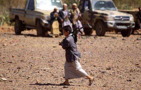 A Yemeni child carries a Kalashnikov rifle as he takes part in a gathering near the capital Sanaa to show support to the Houthis on February 21st, 2019. [Mohammed Huwais/AFP]