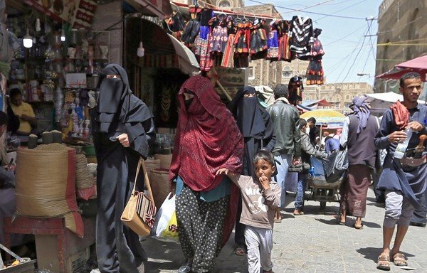 Yemeni women walk past shops in the old city market of Sanaa on March 2nd. [Mohammed Huwais/AFP]