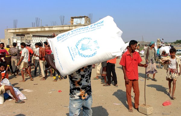 یمنی‌های آواره در استان حجه در تاریخ ۳۰ دسامبر کمک‌هایی که توسط برنامه جهانی غذا با همکاری شورای پناهندگان دانمارک ارائه شده است را دریافت می‌کنند. [عیسی احمد/ خبرگزاری فرانسه]