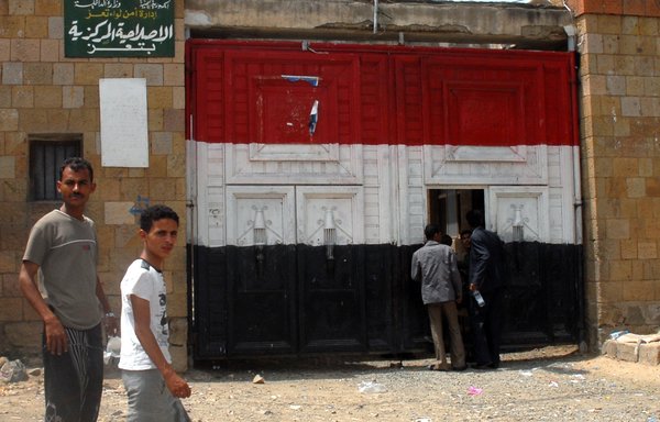 Yemenis walk past the prison in Taez in this file photo from July 5th, 2010. [Gamal Noman/AFP]
