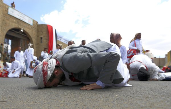 Yemeni prisoners, said to belong to the Yemeni forces, kiss the ground following their release by the Houthis from the central prison in Sanaa before being handed over to their families on September 30th, 2019. [Mohammed Huwais/AFP]
