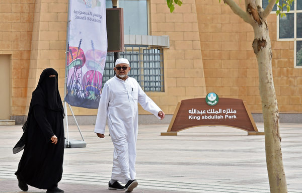 An elderly couple walks on November 12th, 2019 past the main gate of King Abdullah Park where a Yemeni expatriate stabbed three performers during a live play in the Saudi capital Riyadh the previous day. [Fayez Nureldine/AFP]