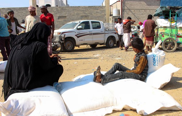 Displaced Yemenis in Hajjah province receive humanitarian aid, donated by the World Food Programme in co-operation with the Danish Refugee Council, on December 30th. [Essa Ahmed/AFP]