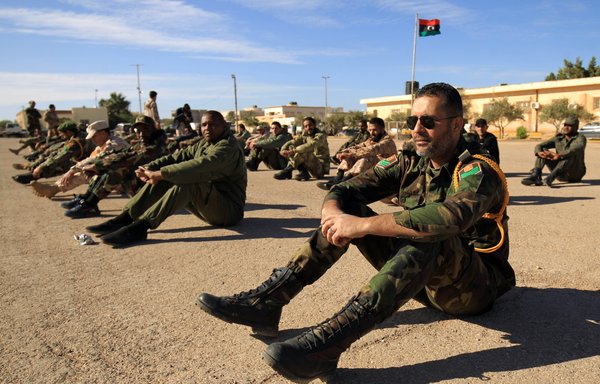 عناصر من كتيبة عسكرية موالية للجنرال الليبي خليفة حفتر، يجلسون خلال تجمع صباحي في مدينة بنغازي الشرقية في 18 كانون الأول/ديسمبر 2019. وتعمل مجموعة فاغنر، وهي منظمة مرتزقة مرتبطة بالكرملين، على تجنيد الشباب السوريين للقتال دعما لحفتر. [عبدالله دوما/وكالة الصحافة الفرنسية]