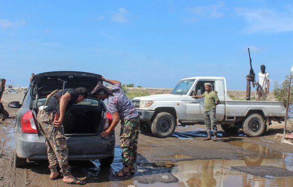 Fighters with Yemen's Southern Transitional Council search a car at a checkpoint in flood-hit Aden on April 26th. [Saleh al-Obeidi/AFP]