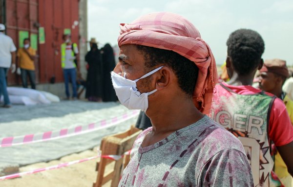 A displaced Yemeni wearing a protective mask arrives to receive relief items distributed by the World Food Programme in Sanaa on April 18th, amid the novel coronavirus pandemic. [Essa Ahmed/AFP]