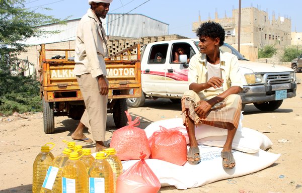Displaced Yemenis receive aid donated by the World Food Programme, in co-operation with the Danish Refugee Council, in Hajjah province on December 30th, 2019. [Essa Ahmed/AFP]