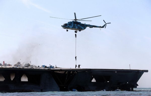 Iran's IRGC troops rappel down a helicopter on a naval vessel during a military drill in the Strait of Hormuz in southern Iran on February 25th, 2015. [Hamed Jafarnejad/FARS NEWS/AFP]