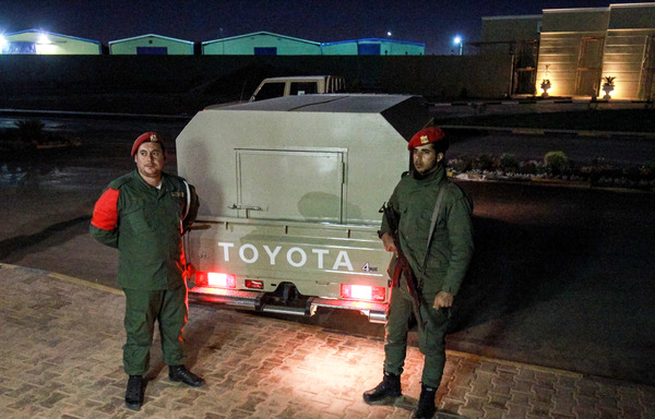 This photo taken May 5th in Libya's eastern city of Benghazi, currently controlled by forces loyal to strongman Khalifa Haftar, shows pro-Haftar military police soldiers standing guard outside a vehicle carrying prisoners captured by Haftar's forces. [Abdullah Doma/AFP]