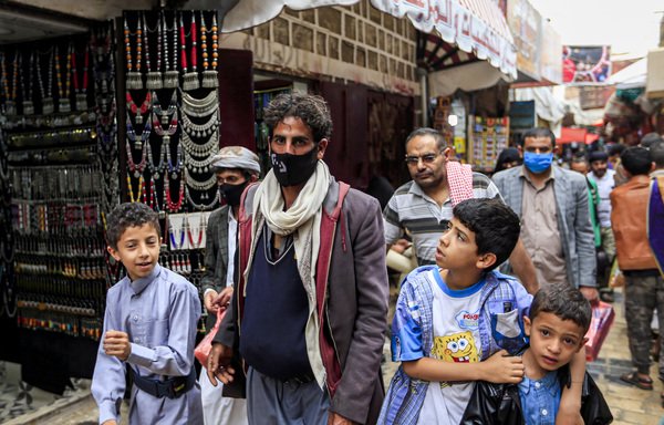 Some Sanaa residents wear masks at an open-air market on May 20th, while others remain without. The Houthis have been criticised for under-reporting coronavirus infections in the city and failing to make precautionary measures mandatory. [Mohammed Huwais/AFP]