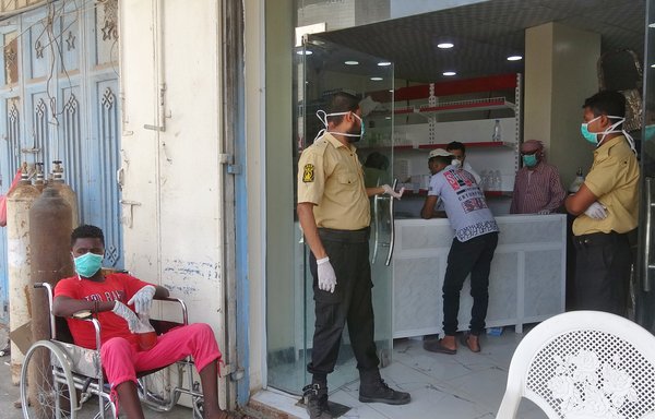 Mask-clad security guards stand at the entrance of al-Kubi hospital in Aden on May 17th, amid fears that coronavirus is spreading unhindered in the Yemeni city. [Nabil Hasan/AFP]