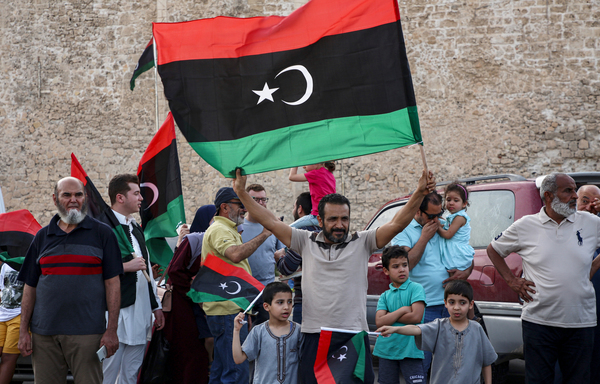 A man waves a Libyan national flag as residents celebrate in the capital, Tripoli, on June 4 after the UN-recognised Government of National Accord (GNA) said it had retaken full control of the capital and its suburbs from a Russian-backed military strongman. [Mahmud TURKIA/AFP]