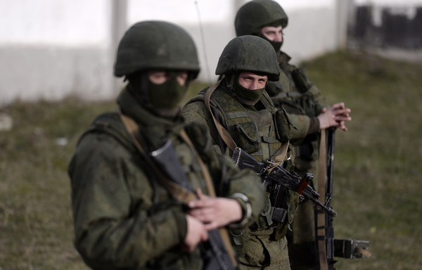 رجال مجهولون يؤمنون الحراسة خارج قاعدة عسكرية أوكرانية في بيريفالنوي في شبه جزيرة القرم بتاريخ 16 آذار/مارس 2014. وكانت أوكرانيا "مسقط رأس" مجموعة فاغنر، وهي مجموعة من المرتزقة تنفذ مشروع الرئيس الروسي فلاديمير بوتين. [ديميتار دلكوف/وكالة الصحافة الفرنسية]