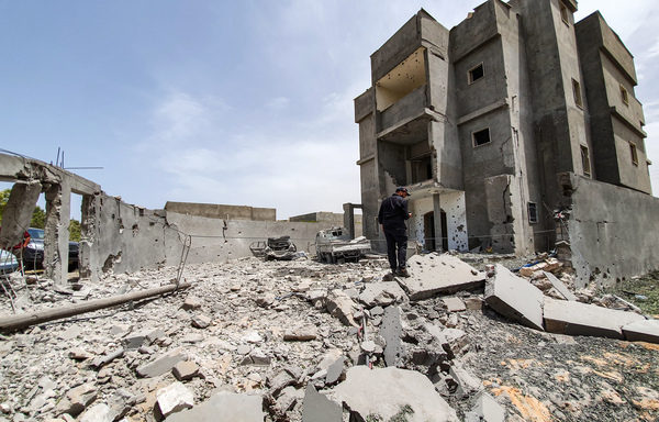 تجمع لليبيين وسط أنقاض في تاجوراء جنوبي العاصمة الليبية طرابلس في 2019، في أعقاب غارة جوية نفذتها القوات الموالية للقائد العسكري المدعوم من موسكو خليفة حفتر. [محمود تركيا/وكالة الصحافة الفرنسية]