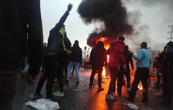 Iranian protestors gather around a fire during a demonstration against an increase in gasoline prices in Tehran, on November 16th, 2019. [AFP]