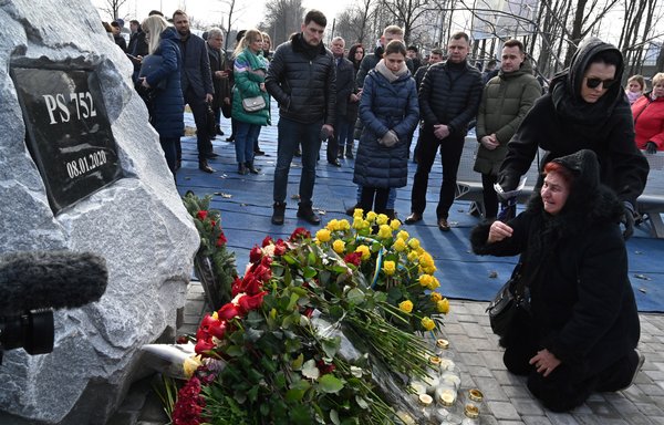 Relatives of the 11 Ukrainians who died in a plane mistakenly shot down by Iran in January, react during a ceremony unveiling a memorial stone at the site of the future monument at the Boryspil International airport outside Kiev on February 17th. [Sergei Supinsky/AFP]