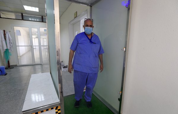 طبيب يقف داخل كشك التعقيم في مختبر الصحة المركزي بصنعاء، يوم 14 حزيران/يونيو. [محمد حويس/وكالة الصحافة الفرنسية]