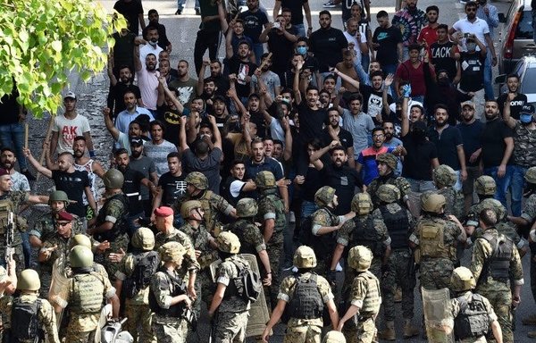 Lebanese soldiers stand guard in front of protestors as clashes erupt with Hizbullah supporters during a demonstration in central Beirut on June 6th. [Photo circulated online]