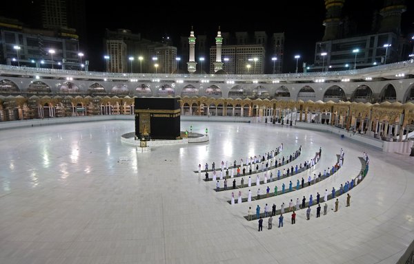 تظهر هذه الصورة تم التقاطها في 23 حزيران/يونيو عددًا قليلا من المصلين يؤدون صلاة الفجر بجوار الكعبة، التي تعتبر أقدس مكان إسلامي، في الحرم المكي في مدينة مكة المكرمة في المملكة العربية السعودية. [سترينجر / وكالة الصحافة الفرنسية]