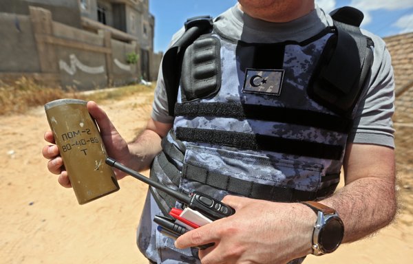 A deminer holds the remains of an explosive device south of the Libyan capital Tripoli, on June 15, 2020. Human Rights Watch earlier in the month accused pro-Haftar forces of laying Russian and Soviet-era land mines as they withdrew from Tripoli's southern districts. [Mahmud TURKIA / AFP]