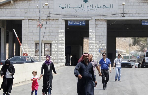 سوريون يعبرون الحدود إلى لبنان في مطلع تموز/يوليو. [محمد عزاقير]
