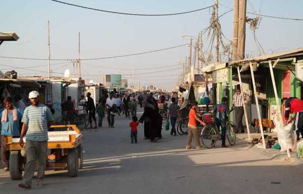 أشخاص يتسوقون في سوق مخيم الزعتري مع رفع حظر التجول الذي فرض للحد من انتشار فيروس كورونا. [حقوق الصورة لباسل الشحمة]