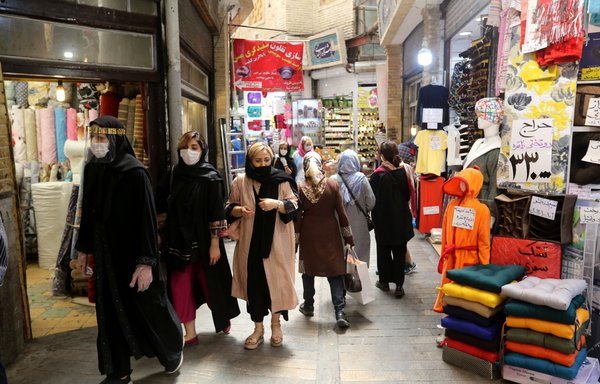 Iranians, wearing protective gear amid the COVID-19 pandemic, shop at the Tajrish Bazaar in Tehran on July 14th. [Atta Kenare/AFP]