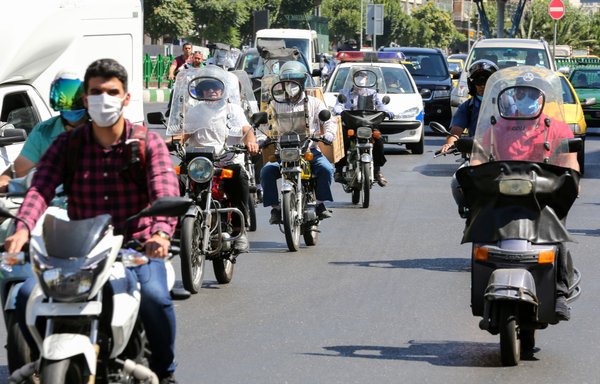 Iranians, wearing protective face masks, ride their motorcycles in the capital Tehran on July 22nd, during the COVID-19 epidemic. The Islamic republic has been battling a resurgence of the virus, with official figures showing a rise in both new infections and deaths since a two-month low in May. [Atta Kenare/AFP]