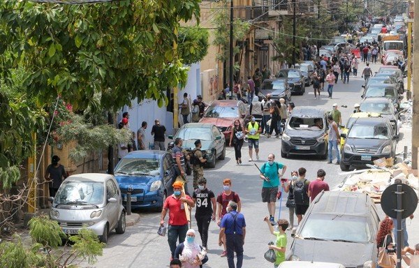Volunteers carry their equipment as they help clear debris in the neighbourhood of Gemmayze on August 6th, following a blast in a warehouse in the Beirut port that killed more than 130 people and caused widespread destruction. [AFP]
