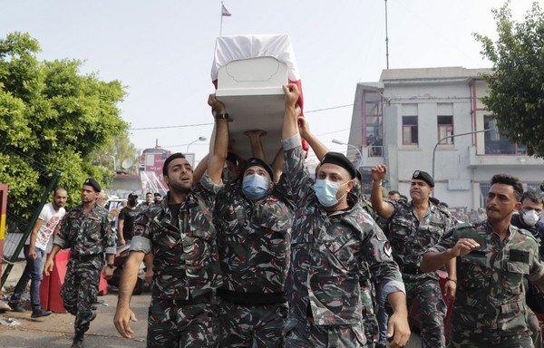 رجال الإطفاء يحملون نعش زميلهم جو نون الذي قتل في الانفجار الضخم الذي وقع في بيروت، وذلك أثناء تشييعه في محطة فوج الإطفاء بمنطقة الكرنتينا القريبة من المرفأ، يوم 12 آب/أغسطس. [أنور عمرو/وكالة الصحافة الفرنسية]