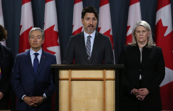 Canadian Minister of Foreign Affairs François-Philippe Champagne and Deputy Minister of Defence Jody Thomas listen as Prime Minister Justin Trudeau speaks during a news conference January 11th in Ottawa. [Dave Chan/AFP]