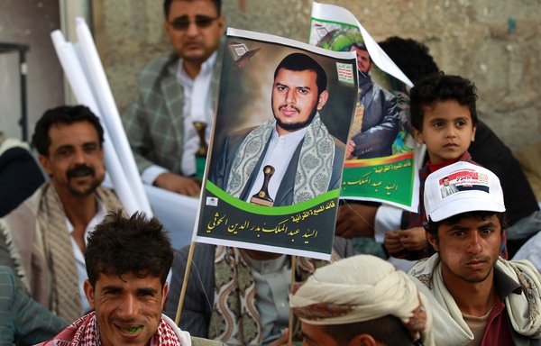 Houthi supporters hold a portrait of militia leader Abdul-Malik al-Houthi during a demonstration on February 27th, 2015 in Sanaa. Al-Houthi is being tried in absentia for communicating with Iran and staging a coup against the government. [Mohammed Huwais/AFP]