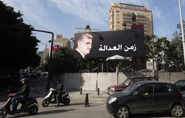 A billboard bearing a portrait of late Lebanese premier Rafic al-Hariri is seen on a main road in Beirut on January 16th, 2014, as four Hizbullah members went on trial in absentia at a UN-backed tribunal in the Netherlands, accused of murdering al-Hariri in a 2005 car bombing. The tribunal delivered its verdict on August 18th, 2020. [Anwar Amro/AFP]