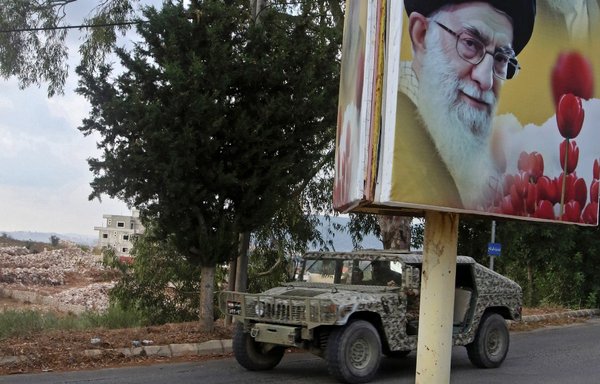 A Lebanese army vehicle patrols a street in Ain Qana after an explosion rocked a Hizbullah site in the southern village on September 22nd. The billboard bears a picture of Iran's Supreme Leader Ali Khamenei. [Mahmoud Zayyat/AFP]