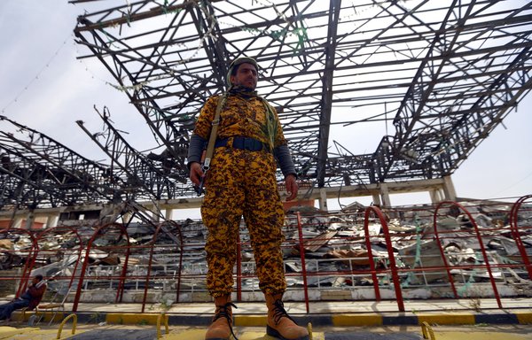 A Houthi fighter stands guard in Sanaa on September 24th, during a ceremony to collect cash, food and other donations for the militia. [Mohammed Huwais/AFP]