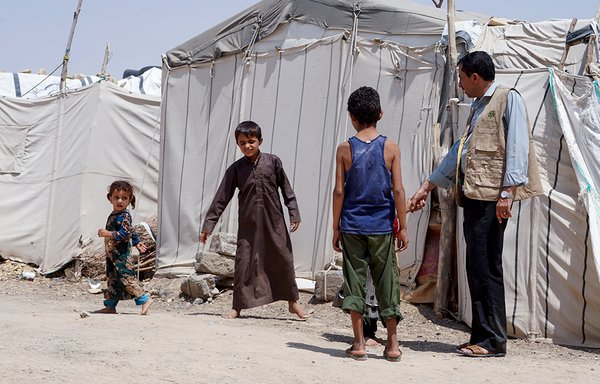 Hadi Ahmed, who was forced to flee his home in the government's last northern stronghold, which is under intense pressure from the Houthis, stands with his children at Suweida displacement camp in Marib province on September 16th. [AFP]