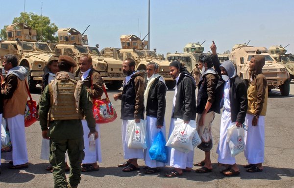 Yemeni prisoners who were held by the Houthis greet officials at the airport in the southern city of Aden on October 16th. [Saleh al-Obeidi/AFP]