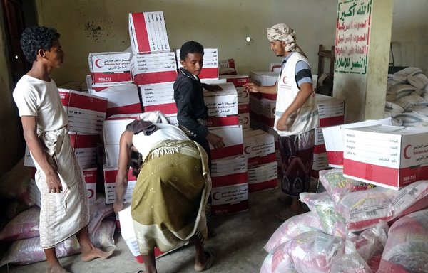 Yemenis drop off boxes of humanitarian aid provided by the Emirati Red Crescent in the town of Mujailis, south of the city of al-Hodeidah, in this file photo from June 6th, 2018. [Nabil Hasan/AFP]
