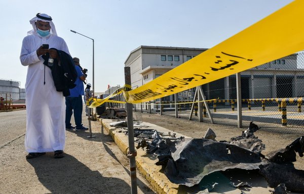 A man stands near debris at a Saudi Aramco oil facility in Jeddah on November 24th following an attack on the facility the previous day. [Fayez Nureldine/AFP]