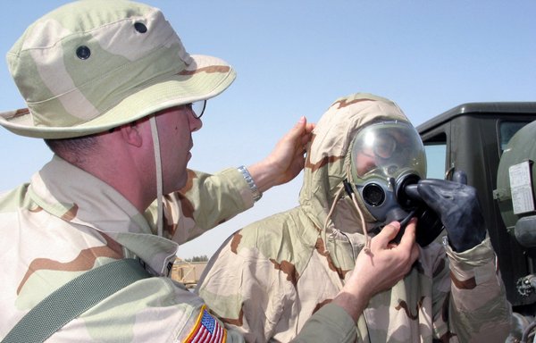 A US Navy commander inspects the fit of a soldier's mask during joint military exercises in Kuwait. [Photo via Kuwait News Agency]