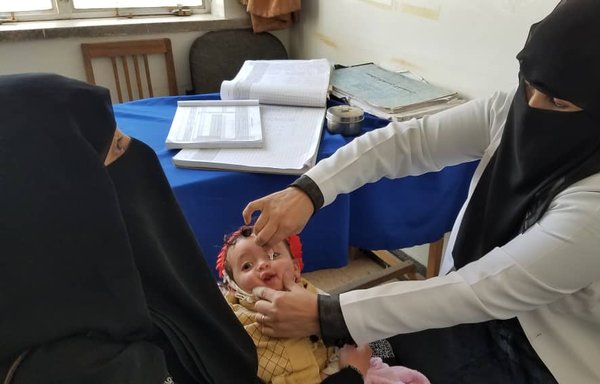An infant receives polio vaccination at al-Zahrawi centre in Sanaa in November. [Haitham Mohammed/Al-Mashareq]