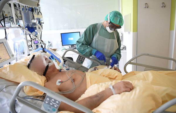 A healthcare worker wearing personal protective equipment treats a COVID-19 patient in Vienna, Austria, on November 27. As of November 30, COVID-19 has infected more than 60 million and killed almost 1.5 million worldwide. [HELMUT FOHRINGER / APA / AFP]