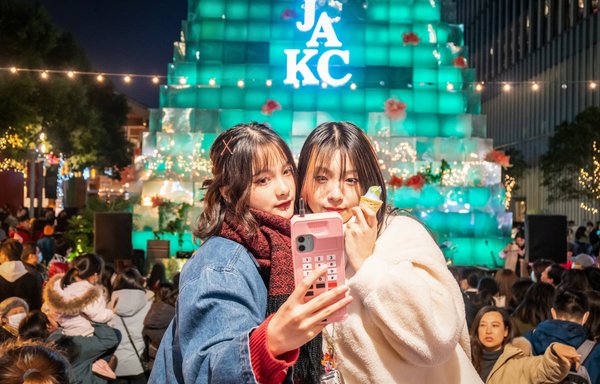 این عکس که در ۴ دی ۱۳۹۹ در شب کریسمس گرفته شده است، مردم را در چین نشان می دهد که بدون ماسک در برابر تزئینات چراغانی کریسمس بیرون یک مرکز خرید در شانگهای عکس سلفی می گیرند. [خبرنگار خبرگزاری فرانسه]