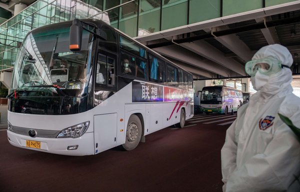 A bus carrying members of the World Health Organisation (WHO) team investigating the origins of the COVID-19 pandemic leaves the Wuhan airport following their arrival  on January 14. [Nicolas Asfouri/AFP]