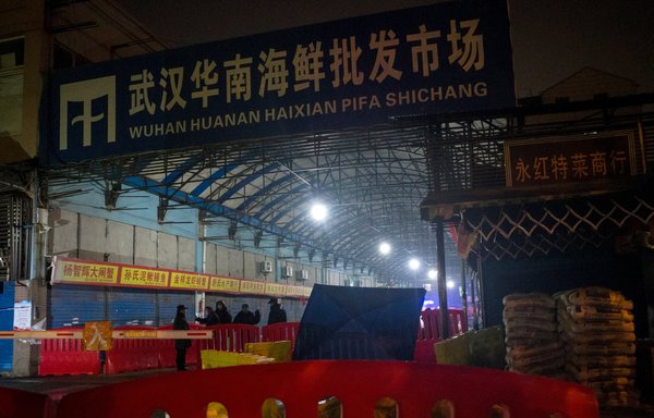 Security guards stand in front of the closed Huanan wholesale seafood market in Wuhan on January 11, 2020, the day China confirmed its first death from COVID-19. [Noel Celis/AFP]