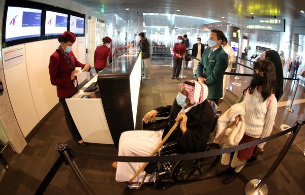 به دنبال ازسرگیری پروازها از عربستان سعودی به قطر، مسافران در یکی از فرودگاه های قطر مدارکشان را تحویل می‌ دهند. [سازمان هواپیمایی کشوری قطر]