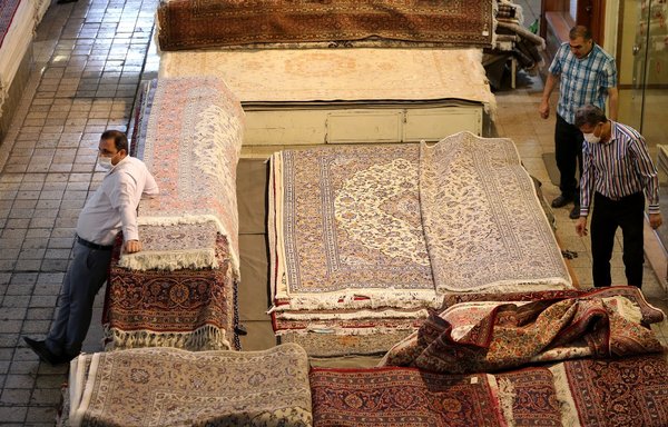 Iranian carpet vendors wait for customers in Tehran's Grand Bazaar on September 30. According to Iranian vendors, carpets exports have decreased amid US-imposed sanctions. [Atta Kenare/AFP]