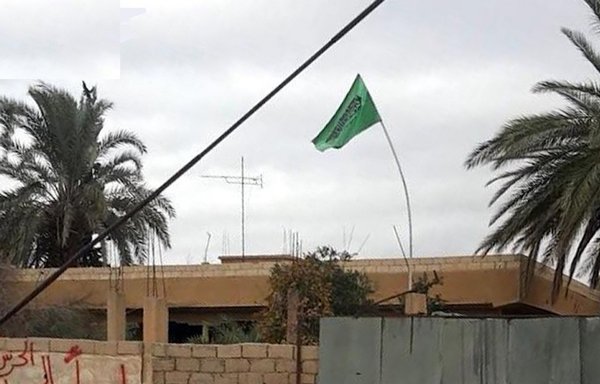A flag flies over the Sayyida Zainab Brigade headquarters in the town of Mahkan in rural al-Mayadeen. [Naher Media]